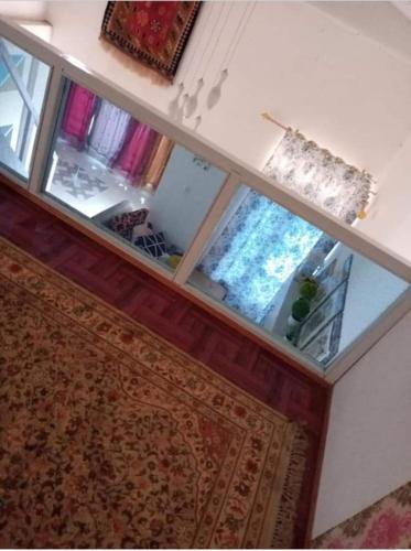 a living room with a mirror and a rug at Villa and Homestay Gubuk Hilwa - Pagaralam in Pagaralam