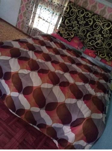 a close up of a bed with a patterned blanket at Villa and Homestay Gubuk Hilwa - Pagaralam in Pagaralam