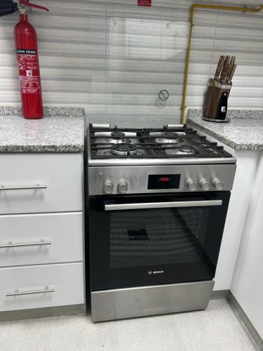 a kitchen with a stove and a red fire extinguisher at Fabulous 1BHK Jadaf Water Front Near Metro Station in Dubai