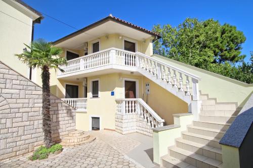 una casa blanca con escaleras y una palmera en Barbic, en Medulin