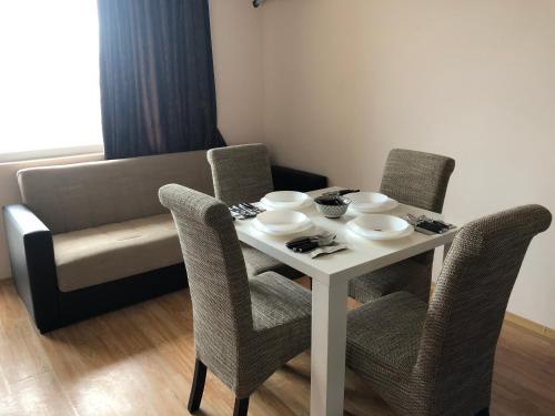 a dining room table with chairs and a couch at Palace De Luxe - Apartments in Pomorie