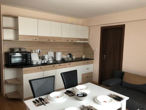 eine Küche mit einem weißen Tisch und einer Mikrowelle in der Unterkunft Palace De Luxe - Apartments in Pomorie