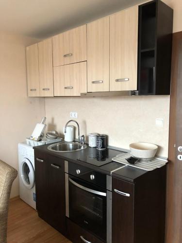 a kitchen with a sink and a stove top oven at Palace De Luxe - Apartments in Pomorie