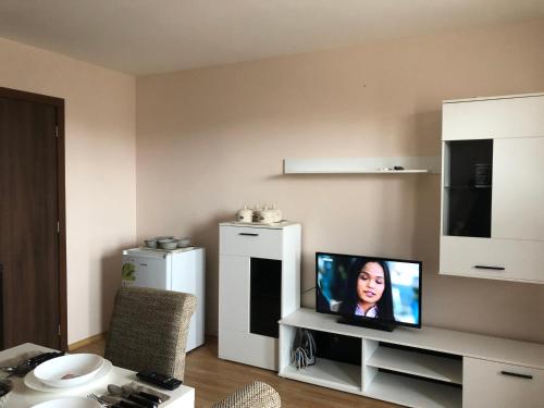 a living room with a television on a table at Palace De Luxe - Apartments in Pomorie