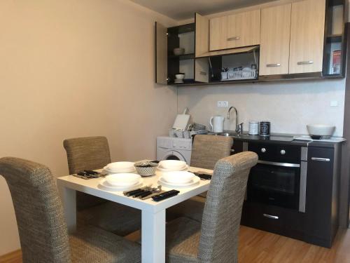 a small kitchen with a table with chairs and a stove at Palace De Luxe - Apartments in Pomorie