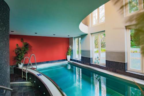 an indoor swimming pool with red walls and a red wall at Schlosshotel Fürstlich Drehna in Drehna