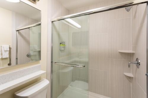 y baño con ducha de cristal y aseo. en Candlewood Suites - Rochester Mayo Clinic Area, en Rochester