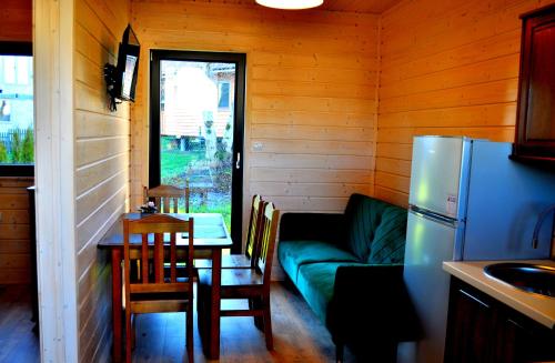 a living room with a couch and a table and a kitchen at Domki M&L in Polańczyk