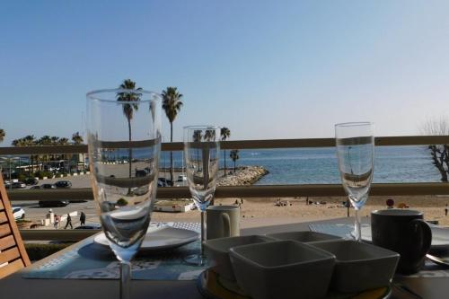 2 copas en una mesa con vistas a la playa en T1 Imperial 2 waterfront air conditioning parking, en Vallauris