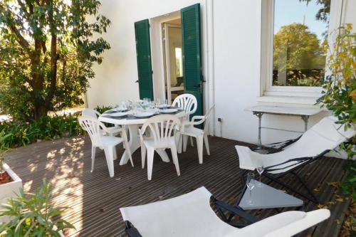 a patio with white chairs and a table and a window at "T3 ground floor of the villa "Les muguets" 3 minutes from the beach" in Vallauris