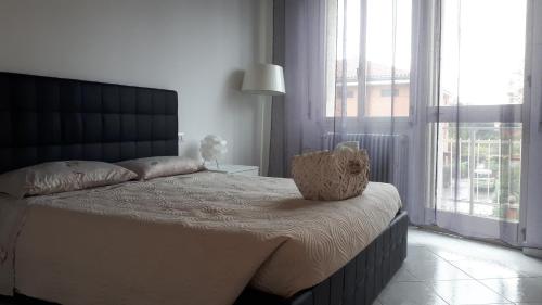 una camera da letto con un grande letto con una grande finestra di casa leonardo ad Azzano San Paolo