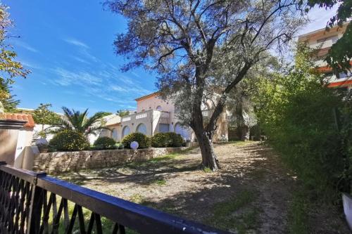 una casa con un albero di fronte a una recinzione di "Villa "Les Oliviers" garden air conditioning city center" a Antibes