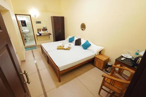 a bedroom with a bed with blue pillows and a mirror at Athirapilly On The Rocks in Athirappilly