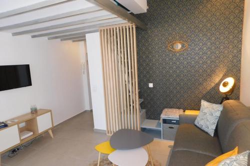a living room with a couch and a tv at T1 "Santa Luccia" with air conditioning in Saint-Laurent-du-Var