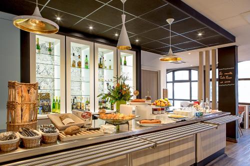 a buffet line with food on display in a restaurant at ibis Colmar Centre in Colmar