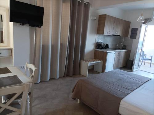 a bedroom with a bed and a kitchen with a table at Palaiokastro view in Karpathos Town