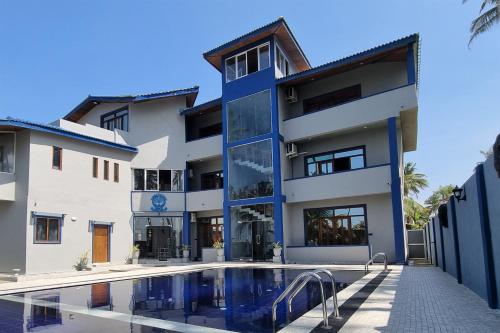 a building with a swimming pool in front of it at Dhammika Beach Palace in Wadduwa