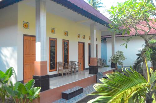 una casa con sedie e tavoli in un cortile di Maja House Penida a Nusa Penida