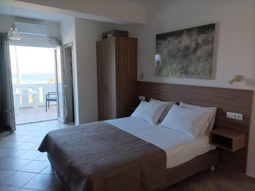 a bedroom with a large bed and a balcony at Palaiokastro view in Karpathos Town