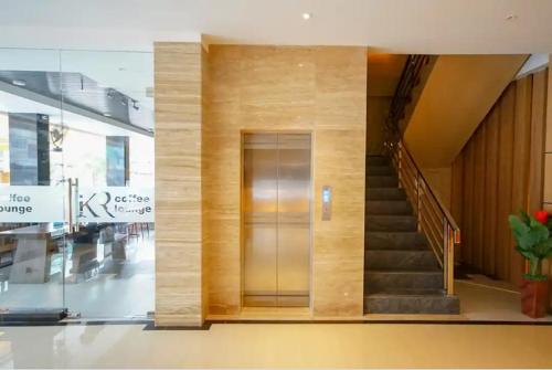 TwoSpaces Living at KR Hotel في باليمبانغ: مصعد في مبنى مع درج