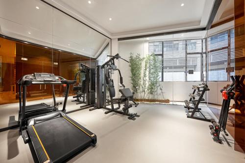 a room with a gym with two tread machines and a window at Fengyue Light Shang Hotel Guangzhou Baiyun Airport Store in Guangzhou