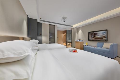 a large white bed in a hotel room at Fengyue Light Shang Hotel Guangzhou Baiyun Airport Store in Guangzhou
