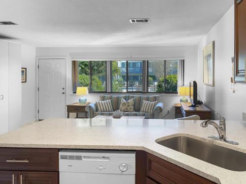 a kitchen with a sink and a living room at Hidden Beach Villas - 111 Villa in Santa Rosa Beach