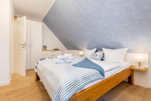 een slaapkamer met een bed met blauwe en witte lakens bij Haus Seekristall Bernstein - Haus Seekristall in Zingst