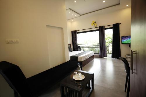 a hotel room with a bed and a balcony at Teaside Inns in Vythiri