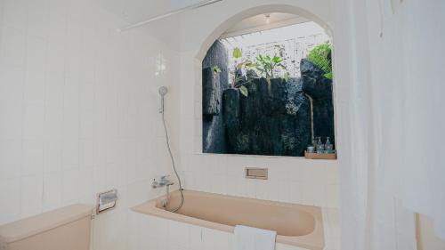 Royal Brongto Hotel في Timuran: حمام مع حوض و لوحة على الحائط