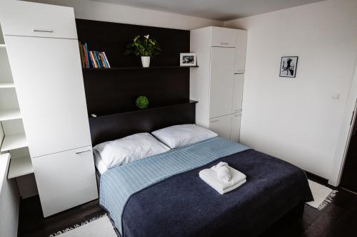 niewielka sypialnia z niebieskim łóżkiem i białymi szafkami w obiekcie AH Kuzmányho w Koszycach
