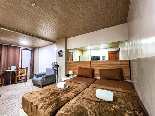 a bedroom with a large bed with a wooden ceiling at Hotel Urban in Baguio