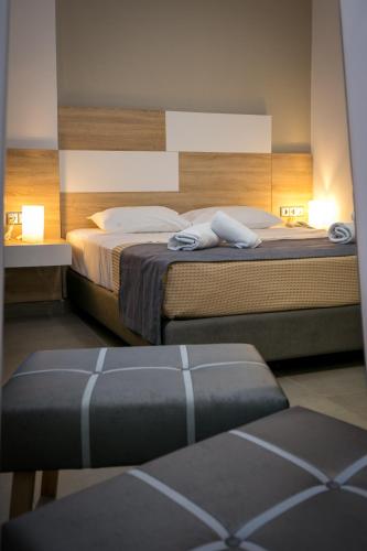 a bedroom with two beds and two ottomans at Astris Sun Hotel in Astris