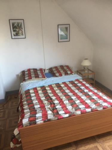 een slaapkamer met een bed met een rode en witte quilt bij CHAMBRE D 'HOTE in Harnes