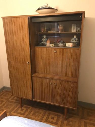 une grande armoire en bois dans une chambre avec un lit dans l'établissement CHAMBRE D 'HOTE, à Harnes