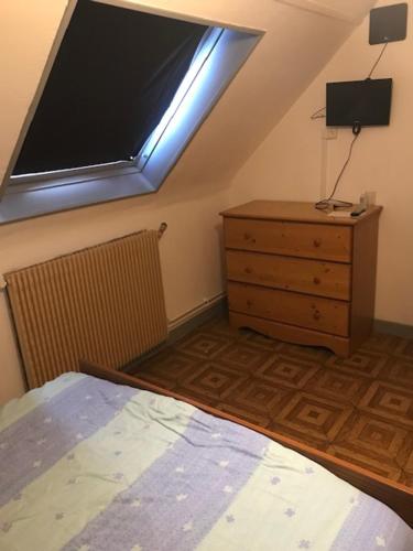 een slaapkamer met een bed, een dressoir en een raam bij CHAMBRE D 'HOTE in Harnes