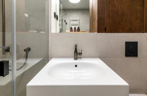 a bathroom with a white sink and a shower at Palatinus Boutique Hotel in Pécs