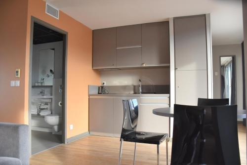 a kitchen with brown cabinets and a table and chairs at Adonis Lyon Dock Ouest in Lyon