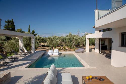 a villa with a swimming pool and a house at Olive green villas in Lefkada Town