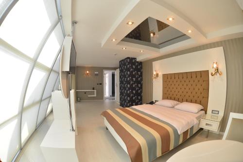 a bedroom with a large bed and a large window at R S CİTY HoTEL in Samsun