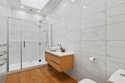 a white bathroom with a sink and a shower at Botham's Beauty - Blenheim Holiday Home in Blenheim