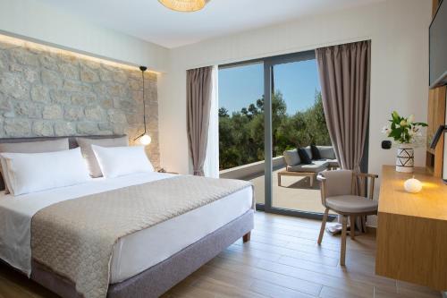 um quarto de hotel com uma cama e uma varanda em Olive green villas em Lefkada