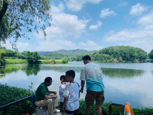 a man and two boys looking at a lake at Mission Hills Hotel Resorts Dongguan in Dongguan
