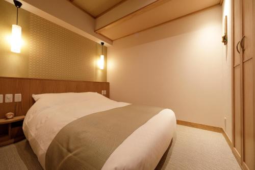 a bedroom with a large bed and a mirror at Onyado Shikishima-kan in Kotohira