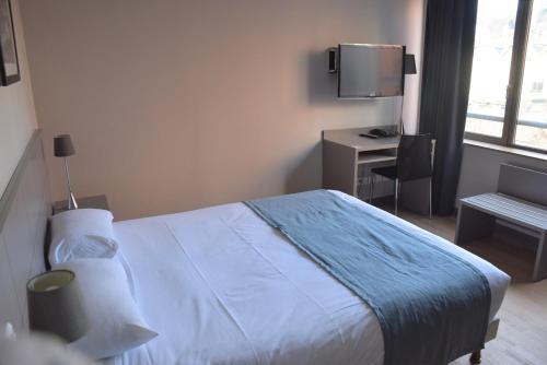 a bedroom with a bed and a desk and a television at Adonis Lyon Dock Ouest in Lyon