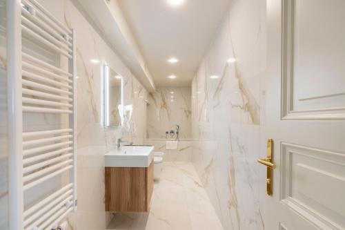 a white bathroom with a sink and a tub at Petrin Tower Residence in Prague