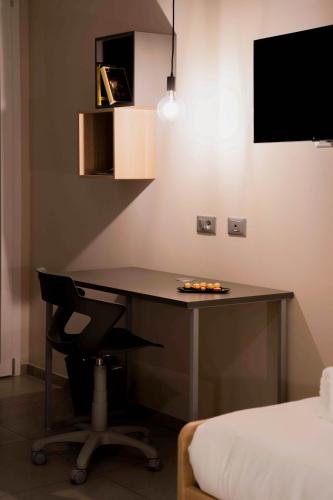 a desk in a room with a bed and a chair at Terranova49 in Novara