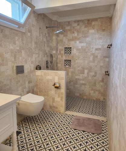 a bathroom with a toilet and a tiled floor at Villa Kayi Kottage in Peaceful calis few minutes from Çaliş sunny Beach in Fethiye