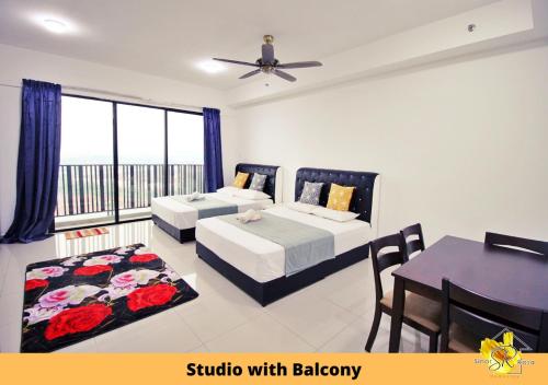 1 dormitorio con 2 camas, mesa y balcón en Sinar Rasa Homestay at I-Soho, I-City, en Shah Alam