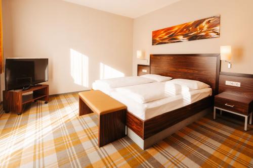 a bedroom with a bed and a flat screen tv at Hotel Liebmann in Lassnitzhöhe